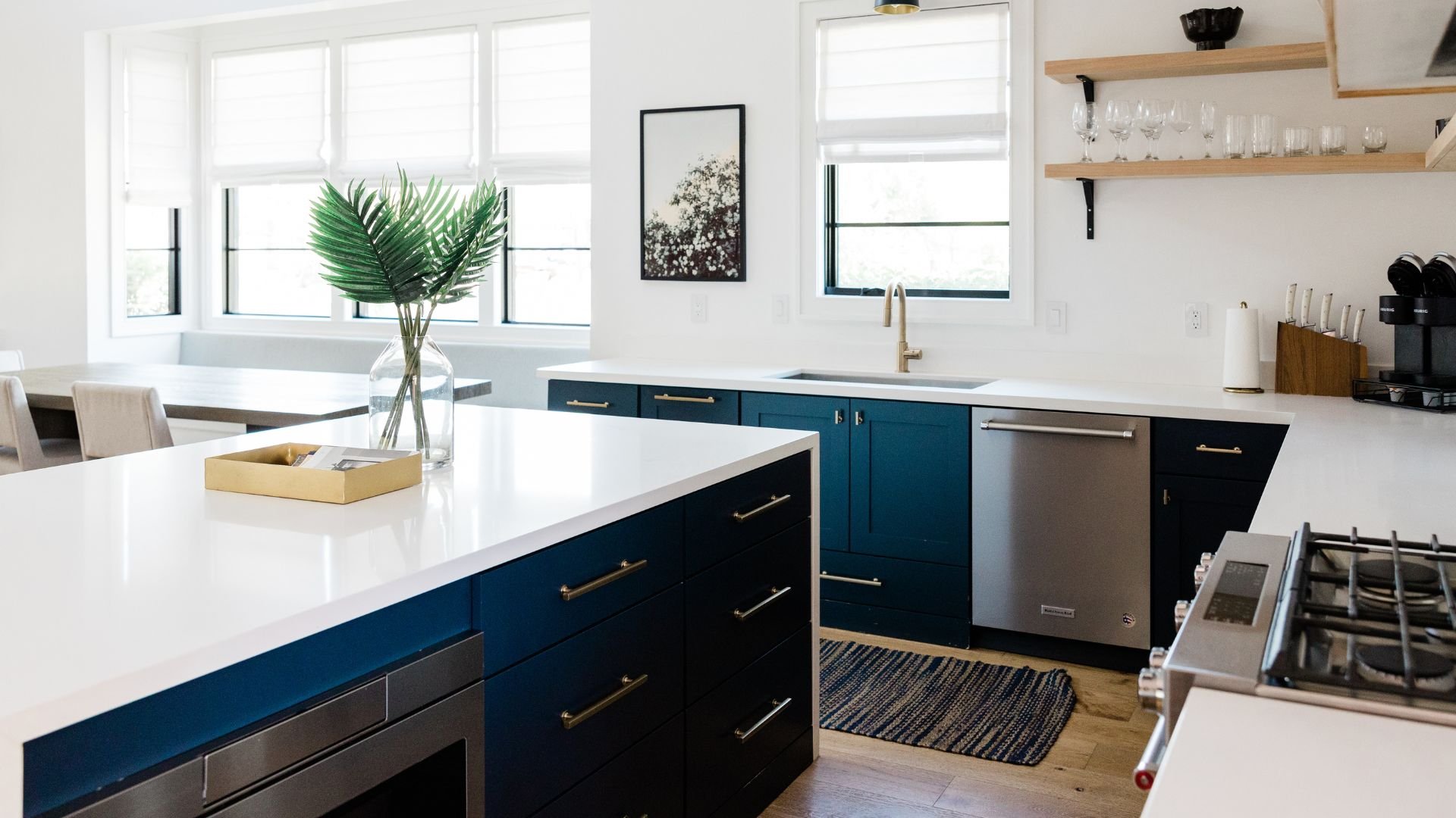 Modern kitchen with blue cabinets, white countertops, and tropical plant