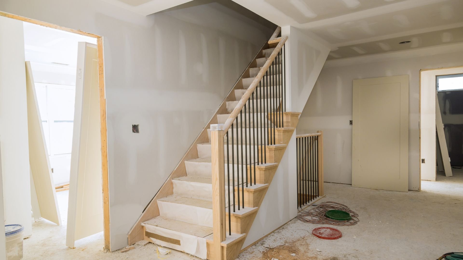 Interior of house under construction with wooden staircase and unfinished walls
