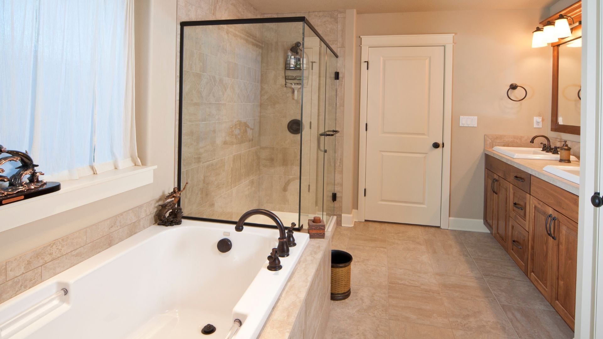 Elegant bathroom with glass shower, white tub, and wooden vanity