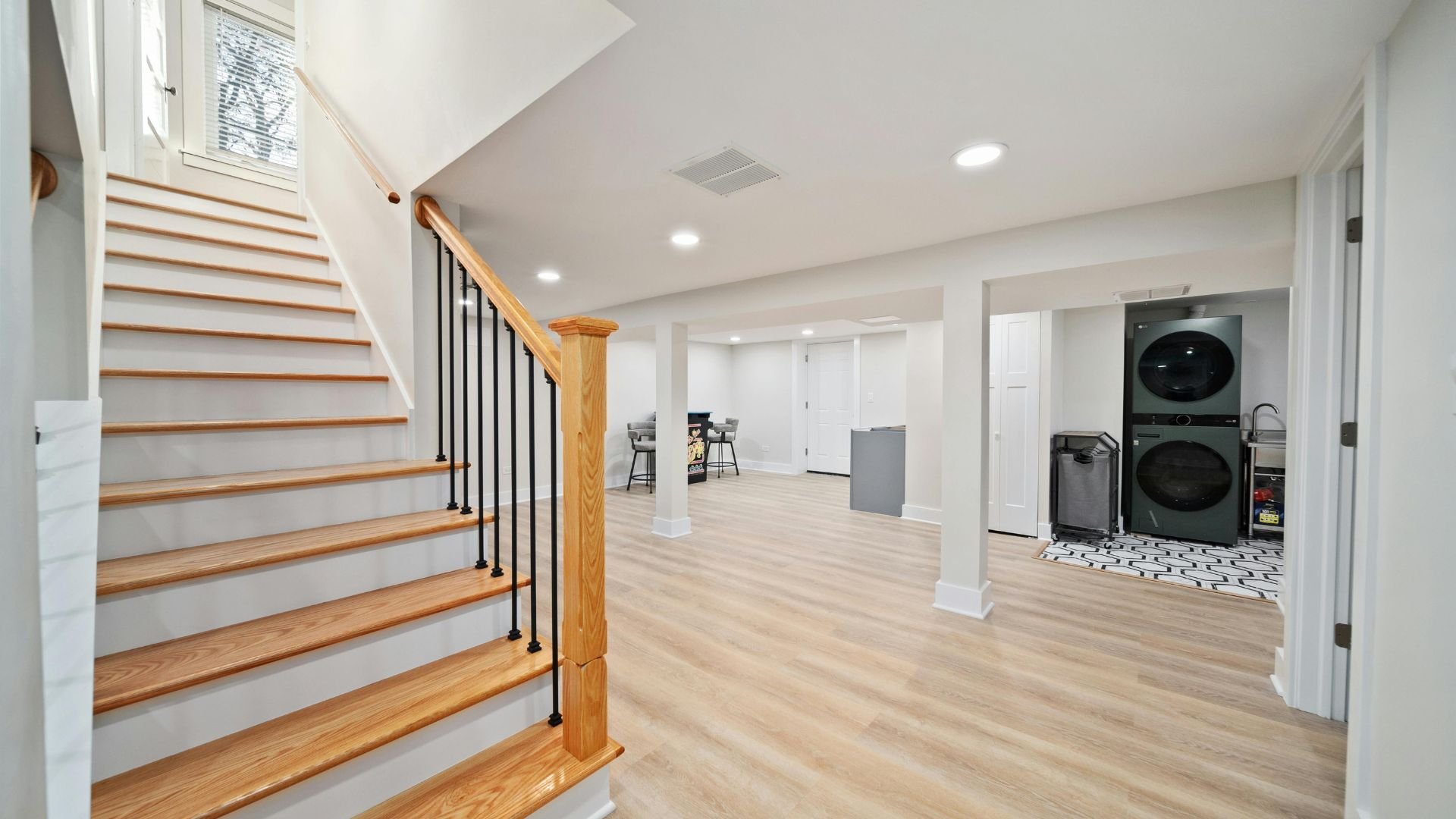 Modern basement interior with wooden stairs and laundry area
